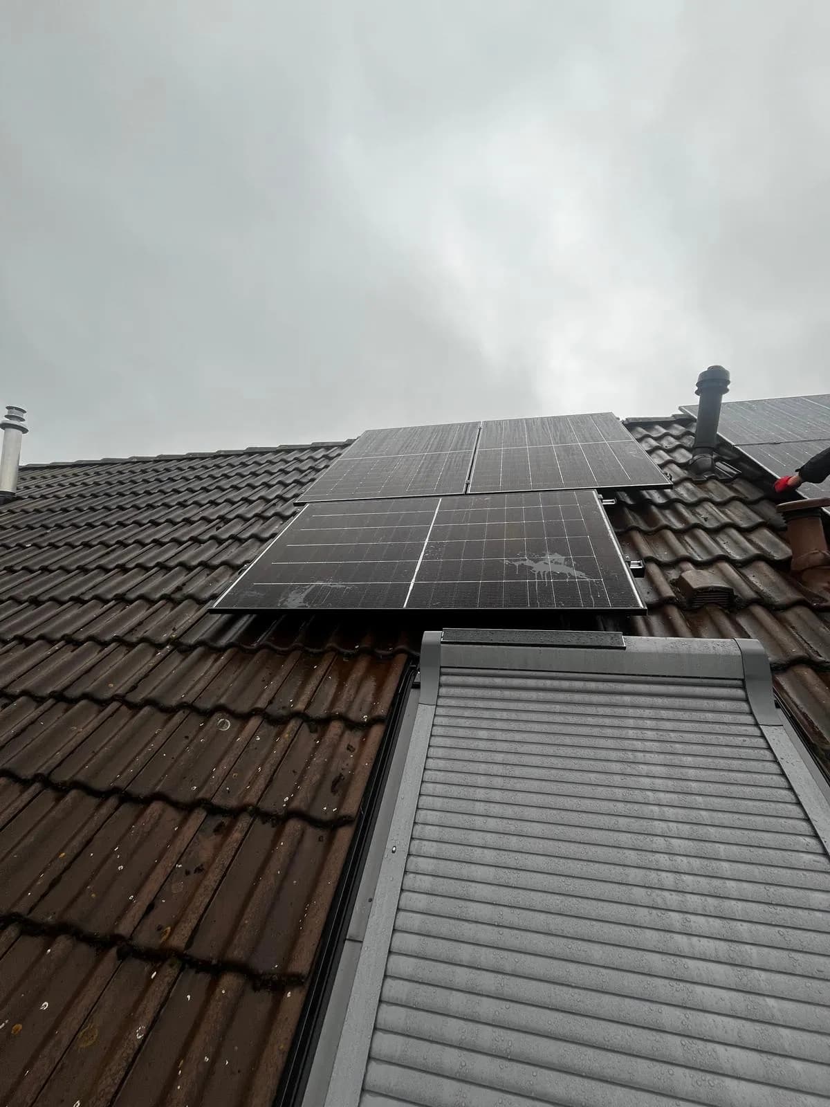 12 kWp Photovoltaik-Anlage auf steilem Altbau-Satteldach mit roten Ziegeln und silbergerahmten Modulen in Pankow
