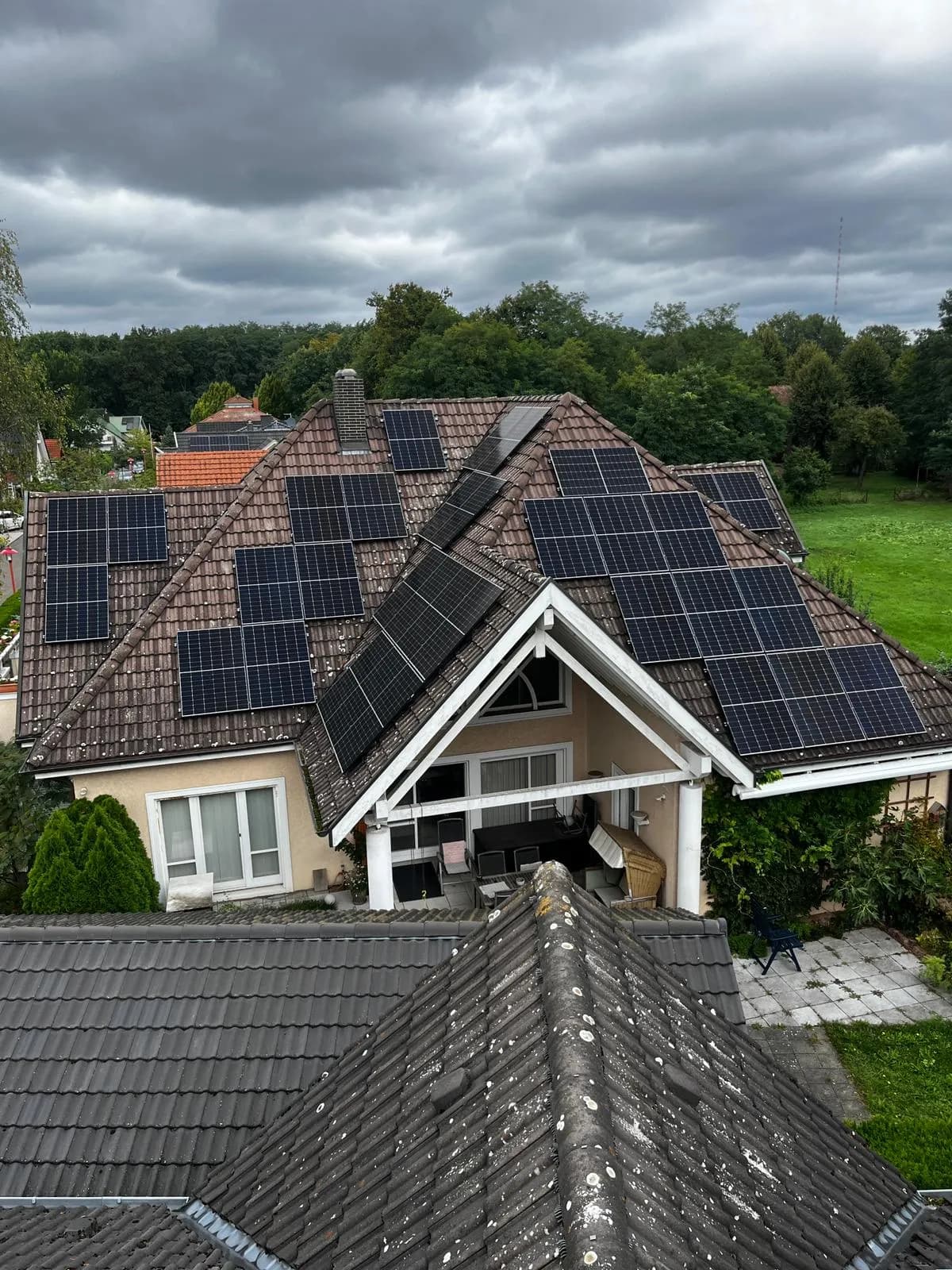 18 kWp Photovoltaik-Anlage auf komplexem Walm-/Krüppelwalmdach mit roten Ziegeln und Full-Black-Modulen in Königs Wusterhausen