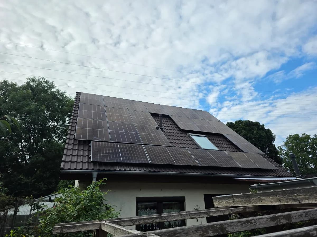 18 kWp Full-Black-Solaranlage auf steilem Satteldach mit schwarzen Ziegeln und Dachfenster in Marzahn